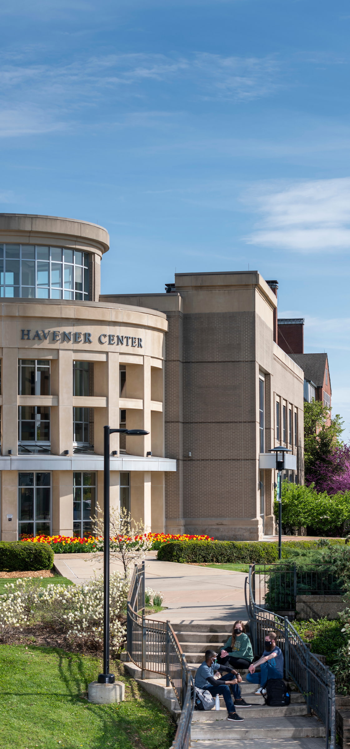 Students sitting together on the stairs in front of Havener Center